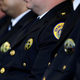 Members of the New Orleans Police Department listen as then-Attorney General Eric Holder discuss the Federal Consent Decree at Gallier Hall on July 24, 2012, in New Orleans. The signing of the federal consent decree was designed to clean up a police force that had been plagued by decades of corruption and abuse.